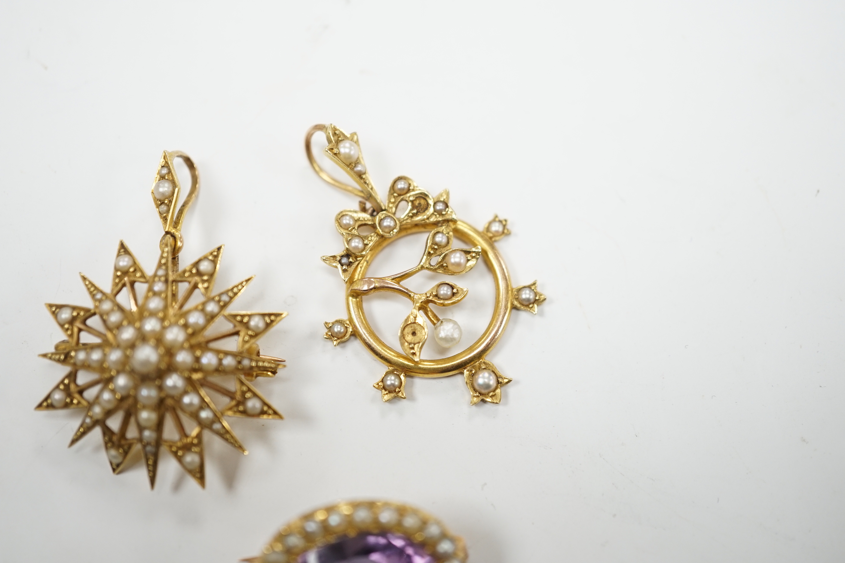 A Victorian 15ct, amethyst and seed pearl foliate pendant and a similar yellow metal and seed pearl set starburst pendant, gross weight 10.6 grams.